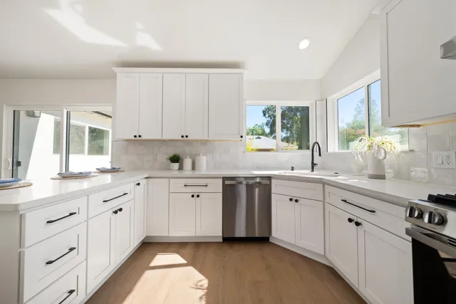a kitchen with cabinets appliances a sink and a window