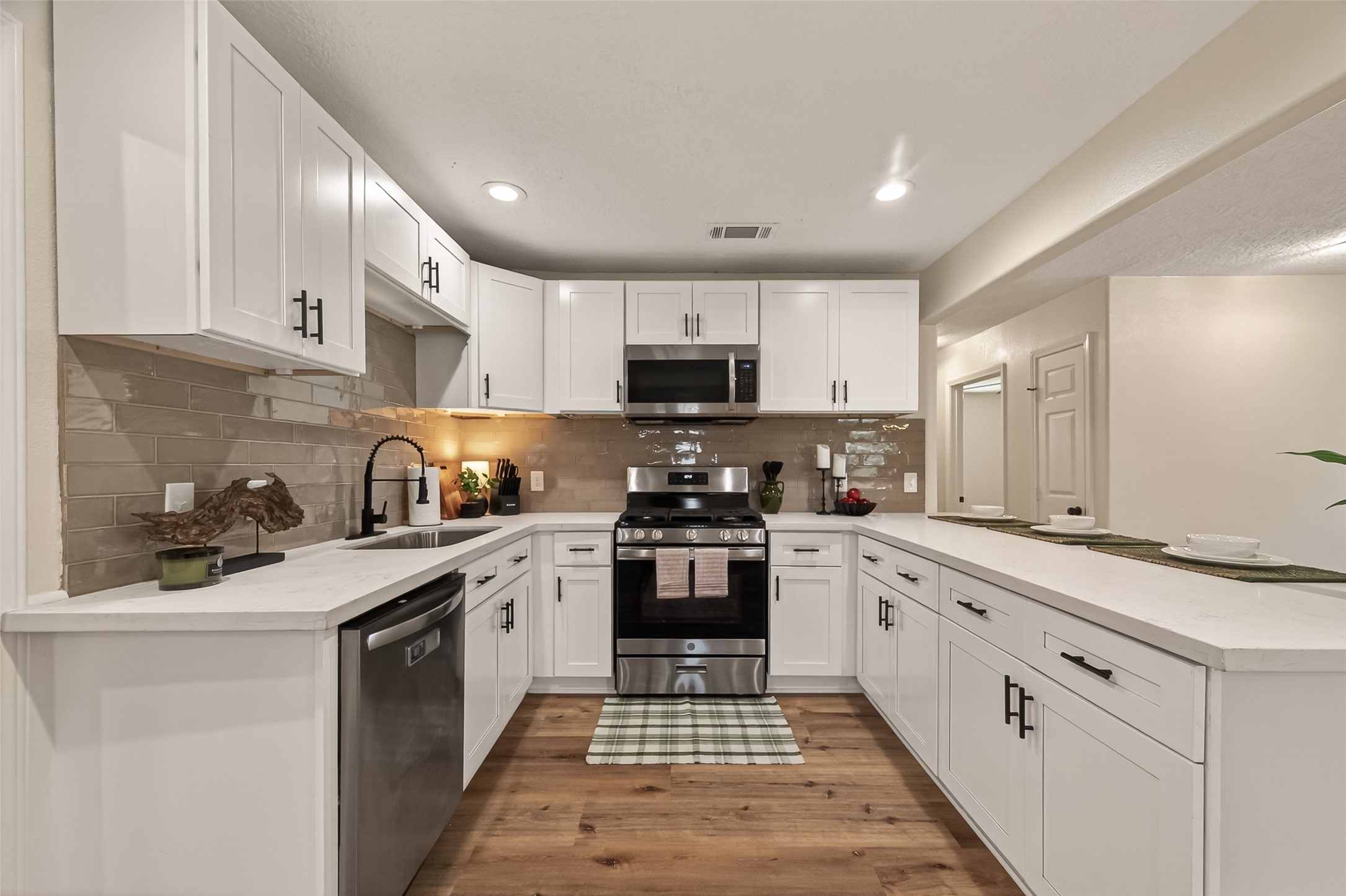 917 South Main Street Highlands, TX 77562 - Photo 13 of 45 a kitchen with granite countertop white cabinets sink and stainless steel appliances