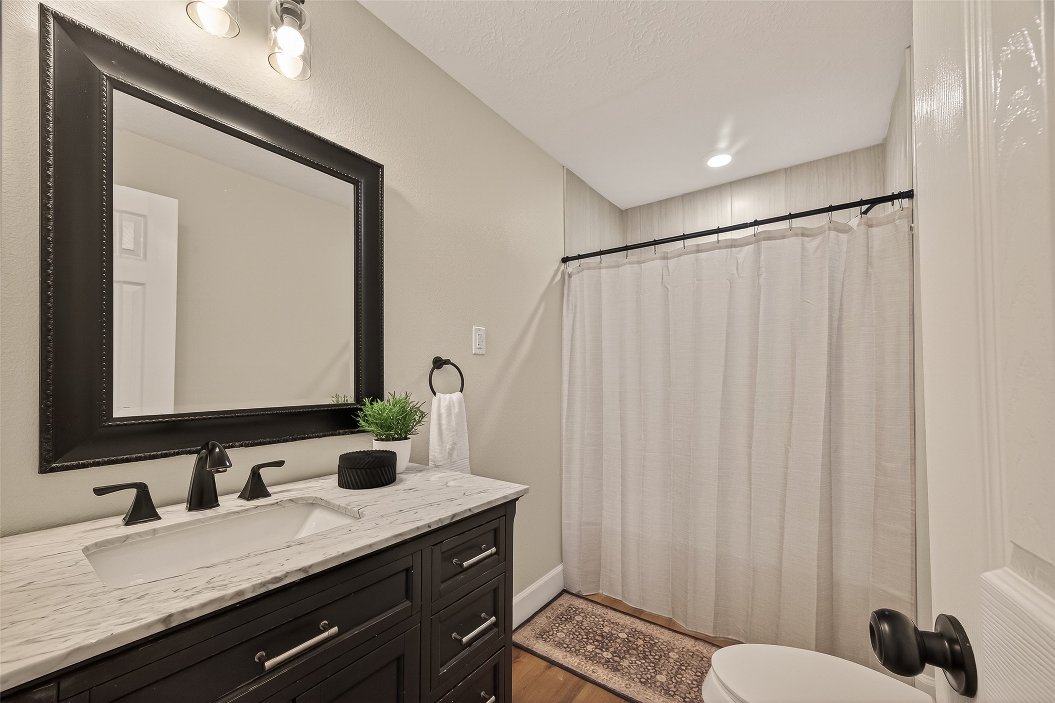 917 South Main Street Highlands, TX 77562 - Photo 17 of 45 a bathroom with a granite countertop sink and a mirror