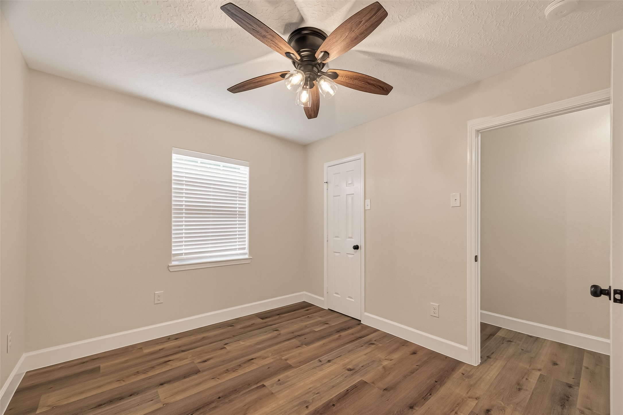 917 South Main Street Highlands, TX 77562 - Photo 19 of 45 a view of an empty room with wooden floor and a ceiling fan