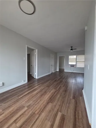 a view of empty room with wooden floor