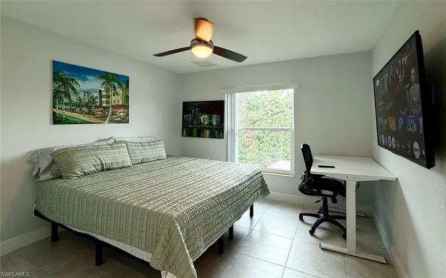 a bedroom with a bed window and a flat screen tv