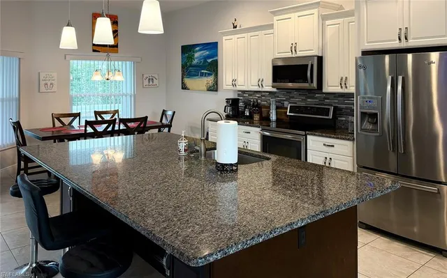 a kitchen with a center island a counter space stainless steel appliances and cabinets