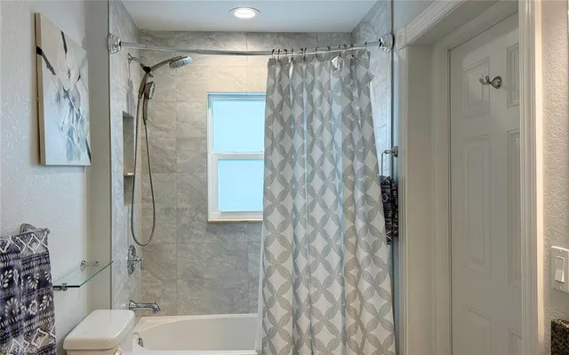 a bathroom with a shower curtain and a toilet