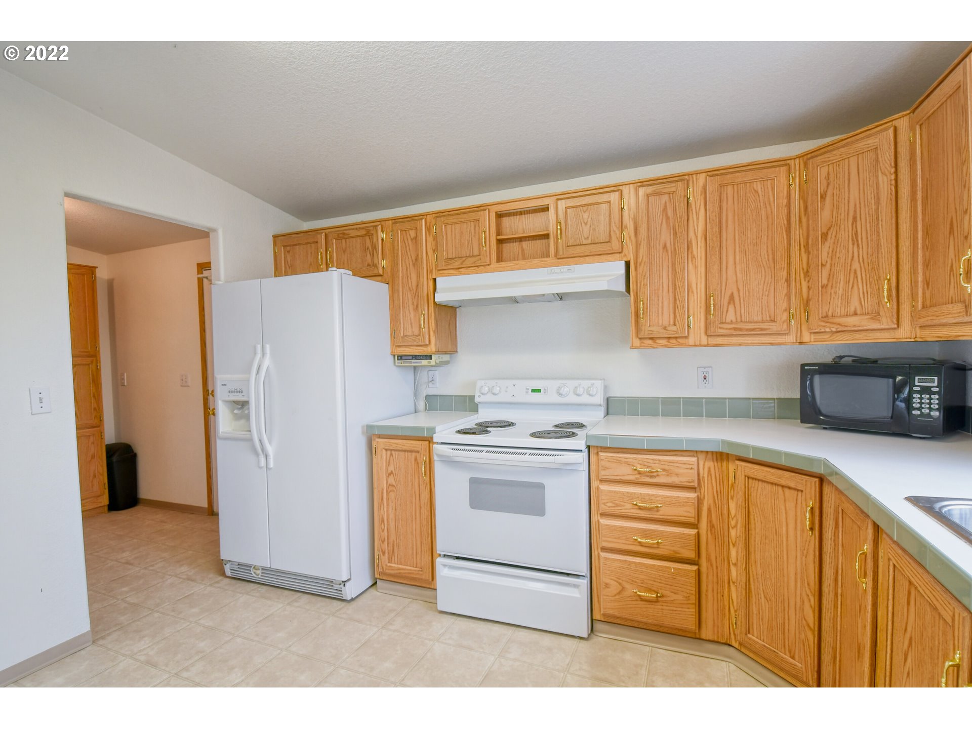 2600 Southwest Goodwin Avenue, Unit 33 Pendleton, OR 97801 - Photo 14 of 29 a kitchen with stainless steel appliances granite countertop a refrigerator a sink dishwasher and white cabinets with wooden floor
