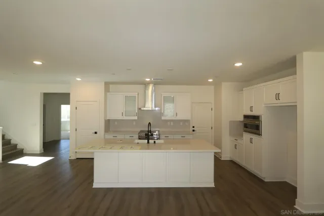 a view of kitchen with stainless steel appliances refrigerator sink and cabinets