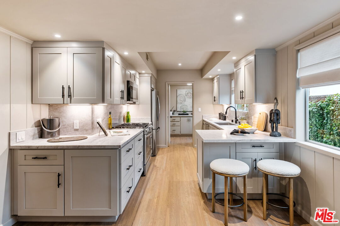 15115 Gilmore Street Van Nuys, CA 91411 - Photo 11 of 26 a kitchen with stainless steel appliances a sink and cabinets