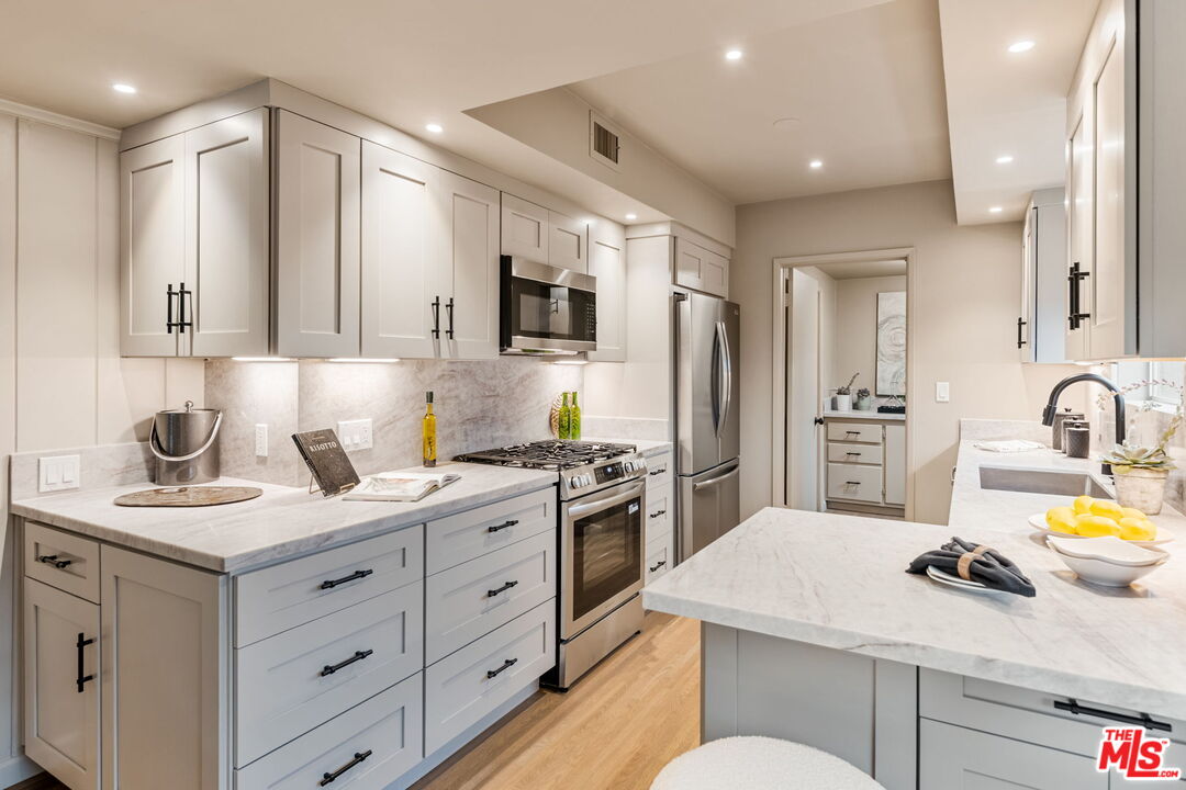 15115 Gilmore Street Van Nuys, CA 91411 - Photo 12 of 26 a kitchen with a sink stove and refrigerator