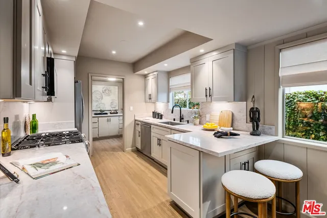 a kitchen with a dining table chairs stove refrigerator and sink