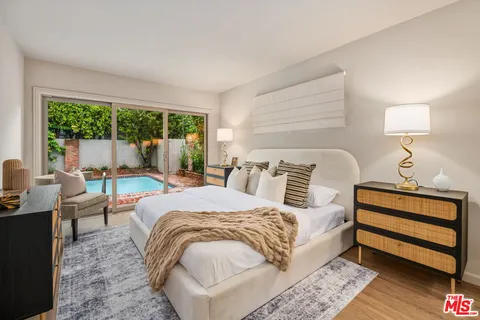 a bed sitting in a bedroom next to a window