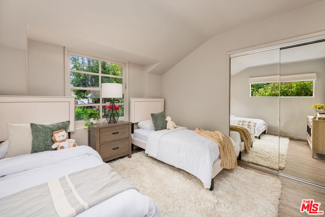 15115 Gilmore Street Van Nuys, CA 91411 - Photo 20 of 26 a bedroom with a bed and a large window