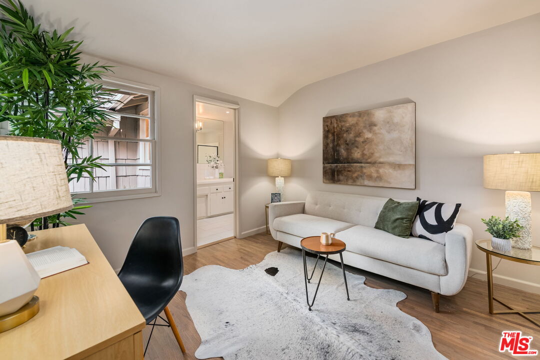 15115 Gilmore Street Van Nuys, CA 91411 - Photo 21 of 26 a living room with furniture and a painting on the wall