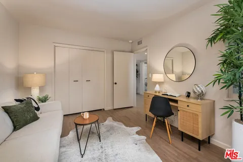 a living room with furniture a mirror and wooden floor