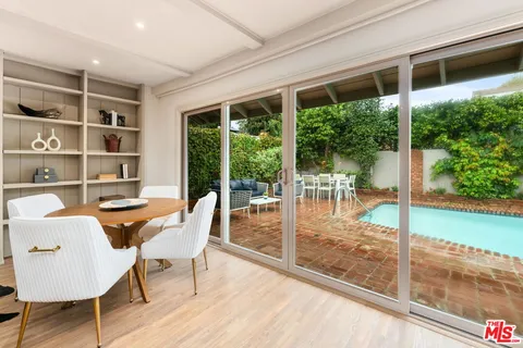 a dining room with furniture wooden floor and a floor to ceiling window