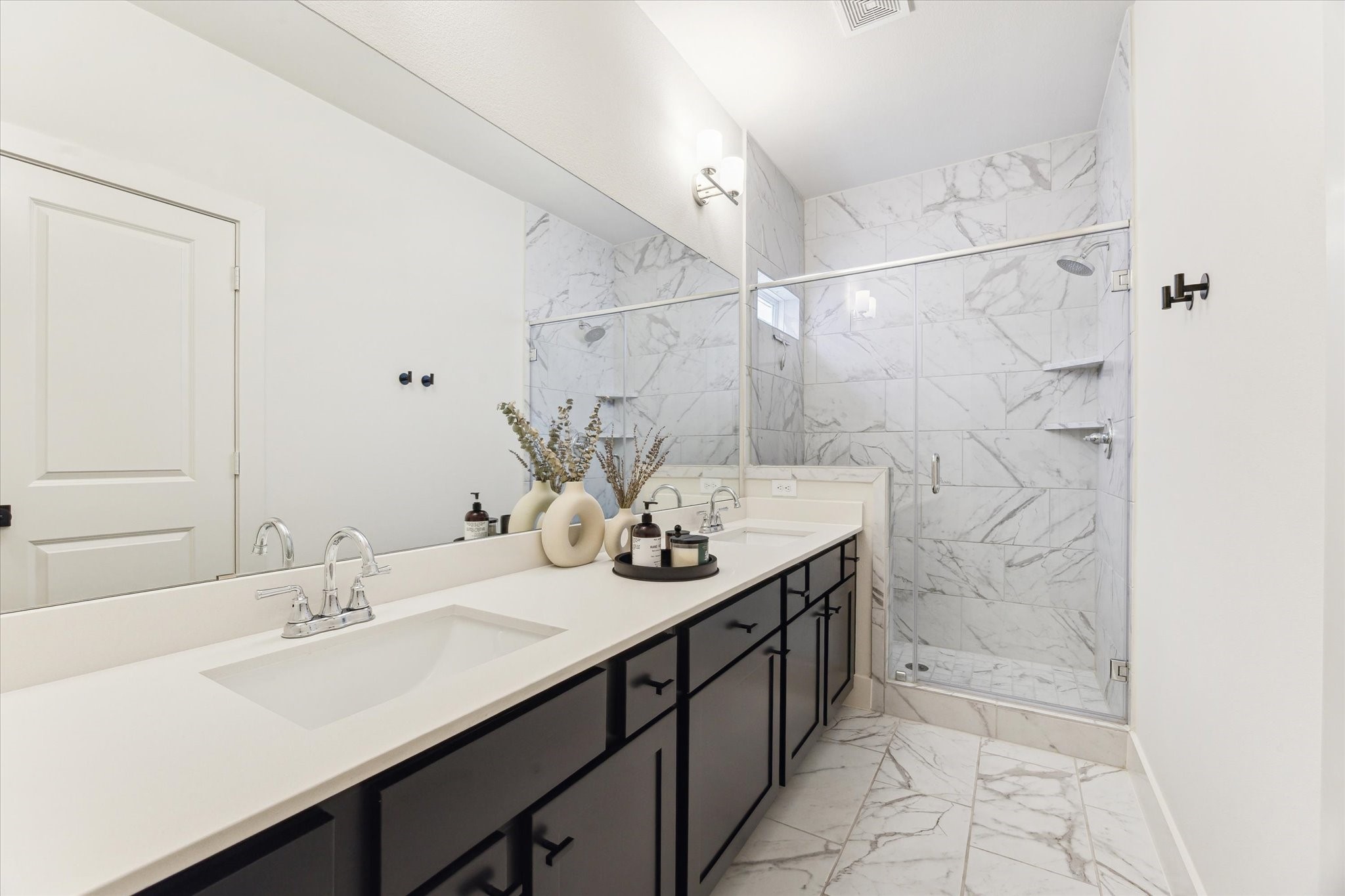 4155 Griggs Road Houston, TX 77021 - Photo 9 of 17 Sleek and sophisticated primary bath featuring gleaming quartz countertops, rich black cabinetry, a spacious walk-in shower, and exquisite tile flooring that adds a modern edge.