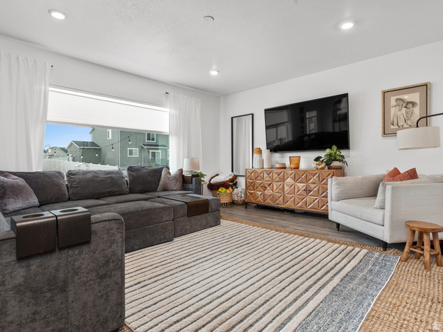 Spacious living area featuring neutral walls, recessed lighting, and wood-finish flooring
