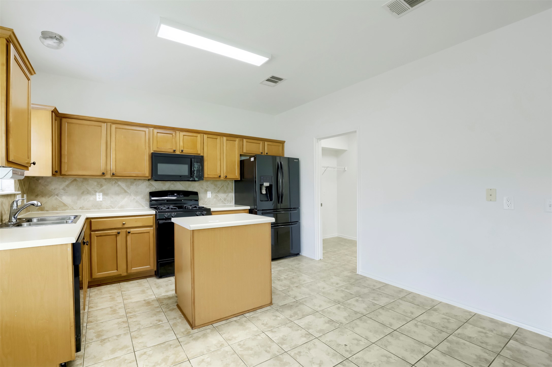 4125 Pebble Ridge Cove Round Rock, TX 78681 - Photo 9 of 30 An inviting kitchen with warm wooden cabinetry and essential appliances awaits new culinary creations.
