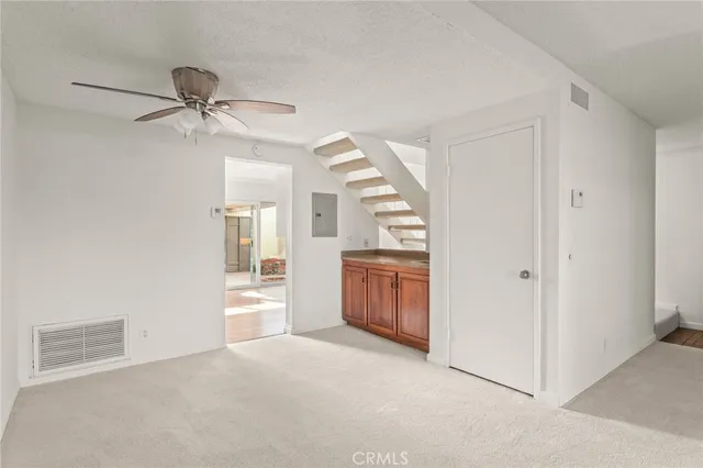 a view of an empty room and a ceiling fan