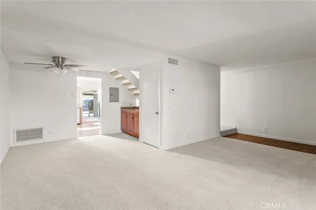 a view of a big room with windows and chandelier fan