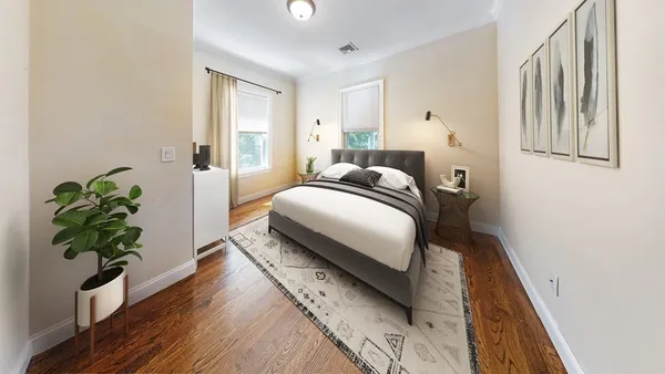 a bedroom with a bed lamp and a potted plant