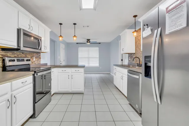 a kitchen with stainless steel appliances a refrigerator sink and microwave