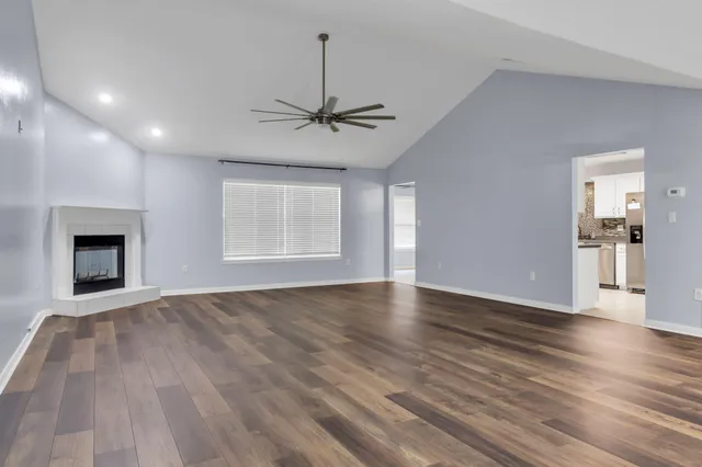 a view of an empty room with glass door and wooden floor