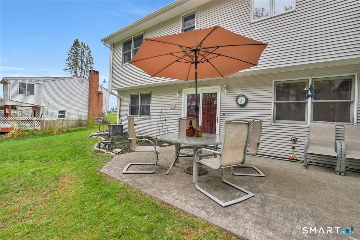 197 Dana Lane Meriden, CT 06451 - Photo 28 of 35 a view of a patio with table and chairs under an umbrella