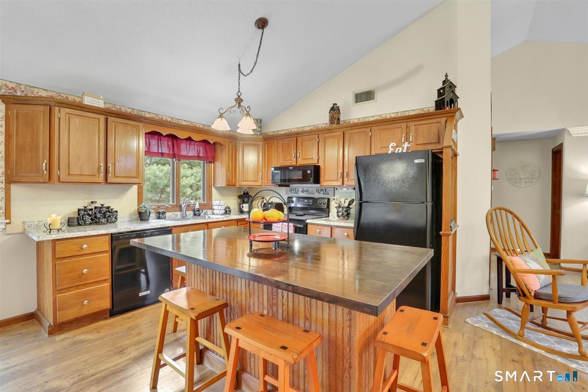197 Dana Lane Meriden, CT 06451 - Photo 7 of 35 a kitchen with stainless steel appliances granite countertop a refrigerator a stove a sink dishwasher a dining table and chairs with wooden floor