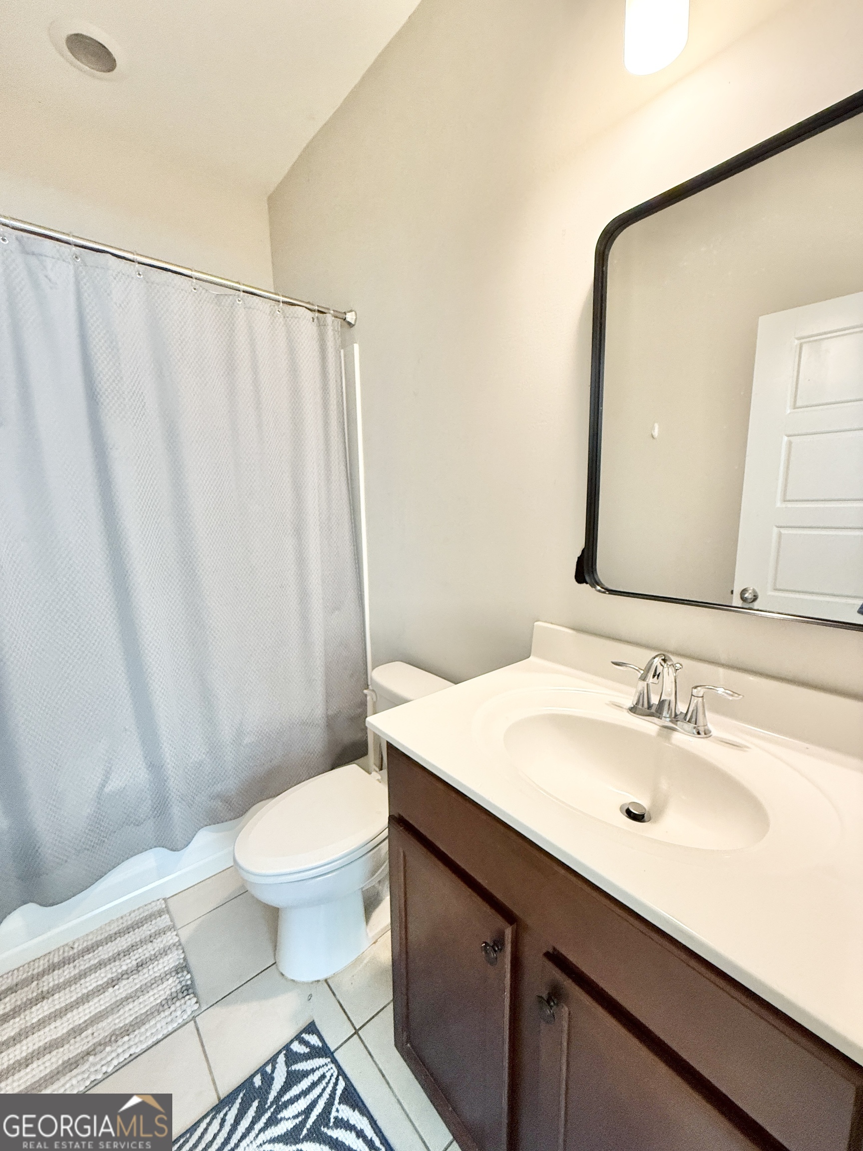 1817 Hislop Lane Atlanta, GA 30345 - Photo 25 of 32 a bathroom with a sink a toilet a mirror and shower curtain