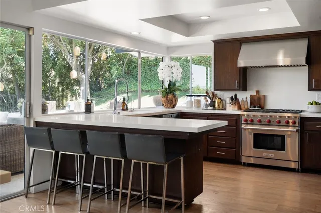 a kitchen with a stove a sink and chairs