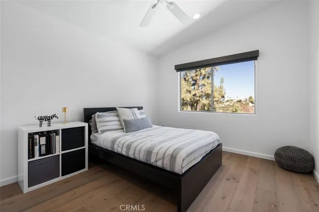 a bedroom with a bed and wooden floor