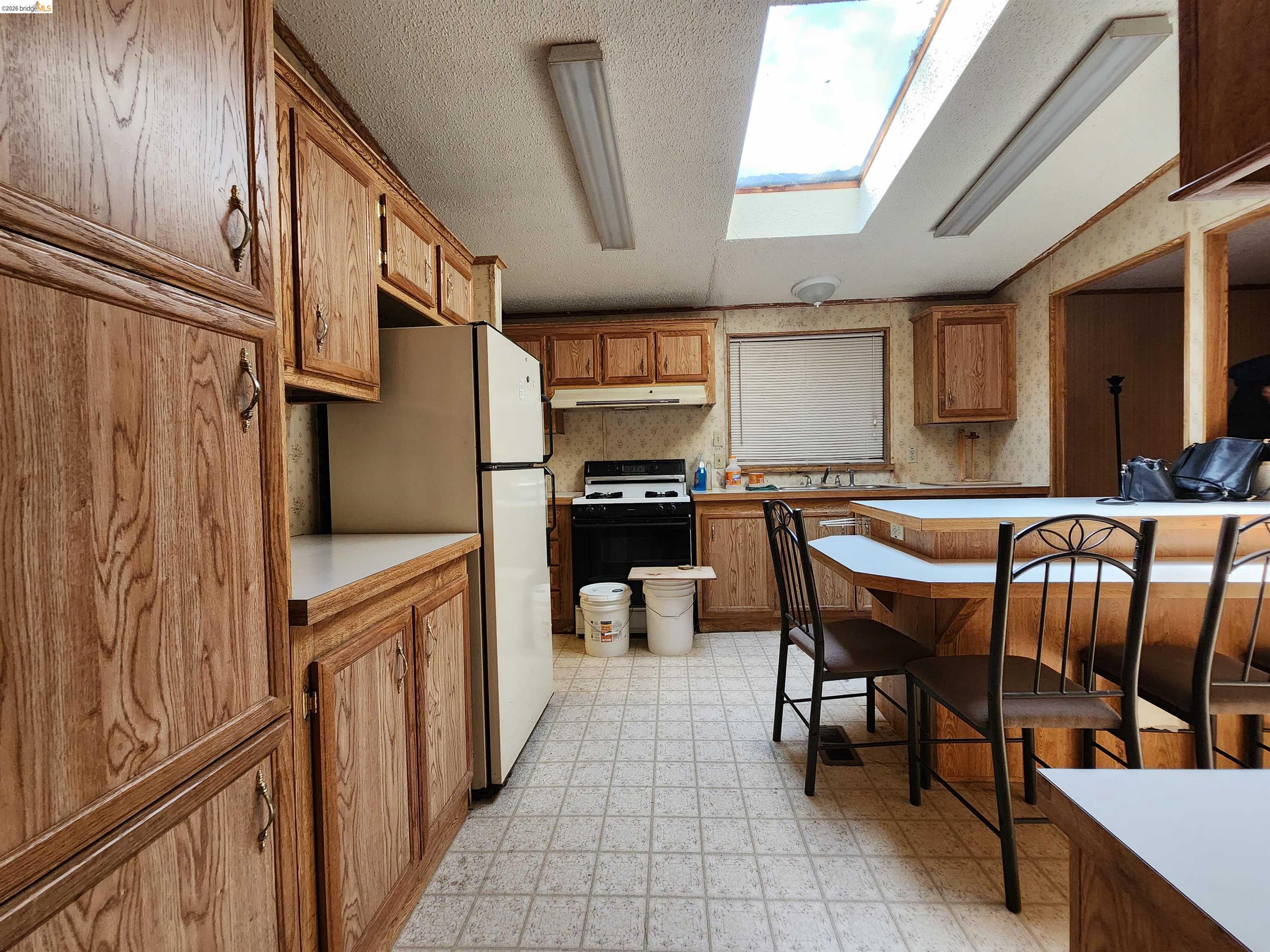 16612 Stagecoach Road Corning, CA 96021 - Photo 4 of 10 a kitchen with stainless steel appliances granite countertop a stove a sink and a refrigerator