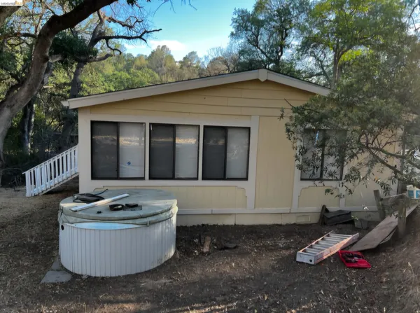 a view of a white house with a tub and chairs