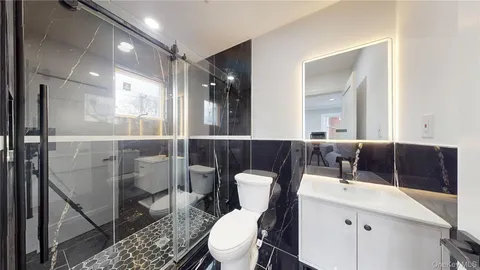 a bathroom with a toilet a sink and mirror
