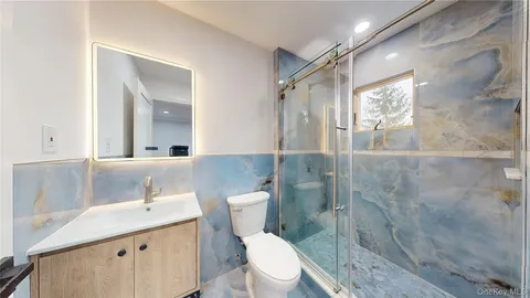 a bathroom with a toilet sink and mirror