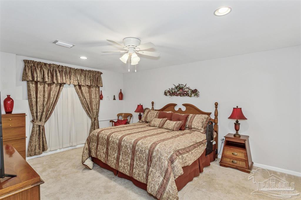 1261 Mahogany Mill Road Pensacola, FL 32507 - Photo 11 of 21 a bedroom with a bed and a chandelier