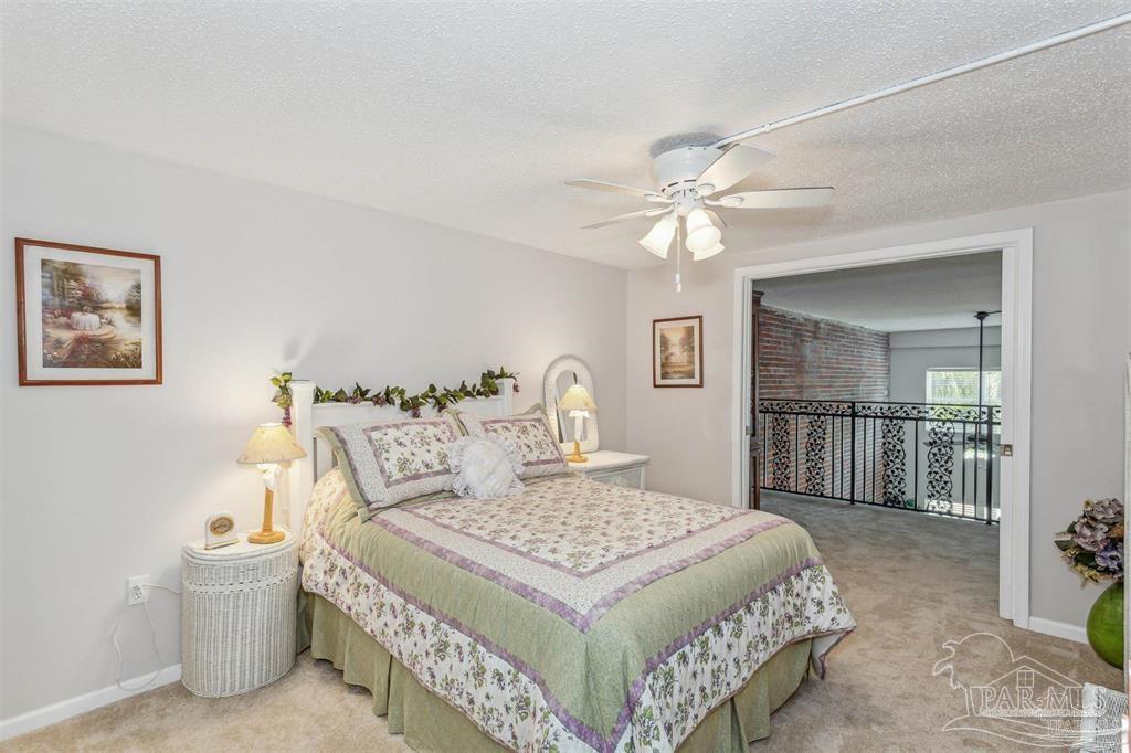 1261 Mahogany Mill Road Pensacola, FL 32507 - Photo 16 of 21 a bedroom with a balcony a bed and a chandelier
