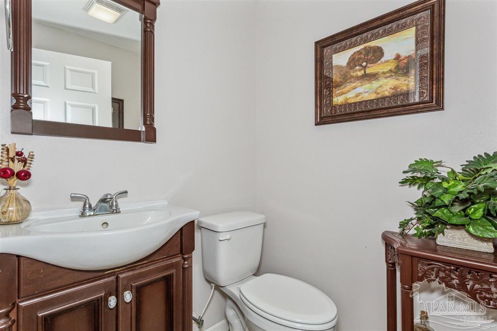 1261 Mahogany Mill Road Pensacola, FL 32507 - Photo 10 of 21 a bathroom with a toilet a sink and mirror