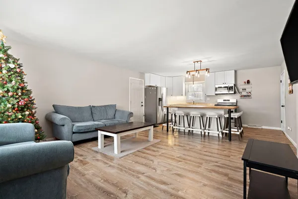 a living room with furniture and a dining table with wooden floor