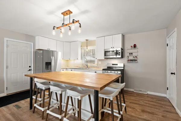 a kitchen with stainless steel appliances granite countertop a stove a refrigerator and a dining table