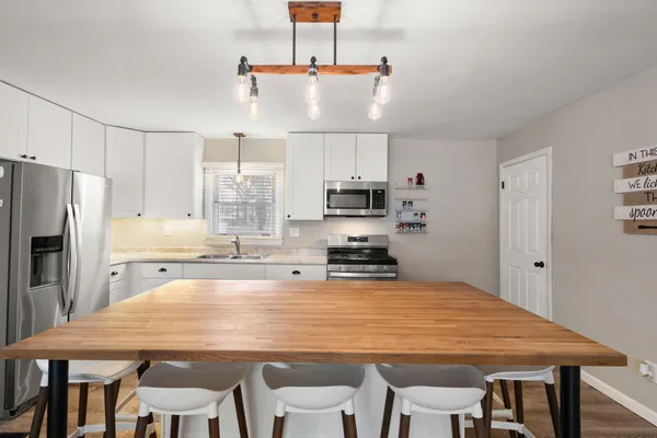a kitchen with kitchen island a refrigerator stove microwave and cabinets