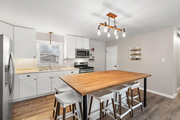 a kitchen with stainless steel appliances granite countertop a kitchen island hardwood floor and a sink