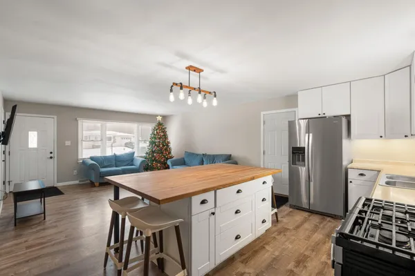 a kitchen with a table chairs refrigerator and microwave
