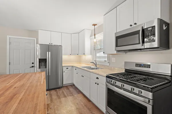 a kitchen with stainless steel appliances a stove a microwave and cabinets