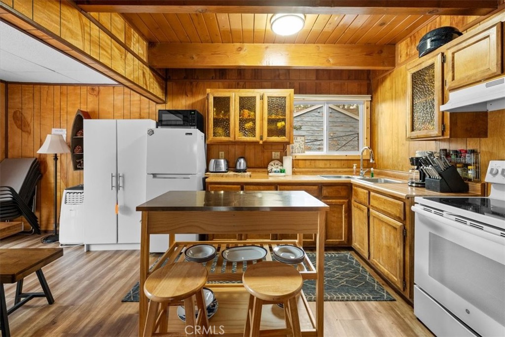 567 Highland Road Big Bear Lake, CA 92315 - Photo 12 of 42 a kitchen with a table chairs refrigerator and cabinets