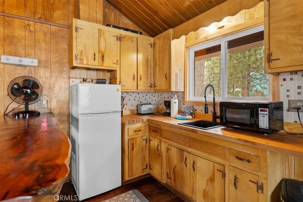 567 Highland Road Big Bear Lake, CA 92315 - Photo 22 of 42 a kitchen with a refrigerator a stove a sink dishwasher and white cabinets with wooden floor