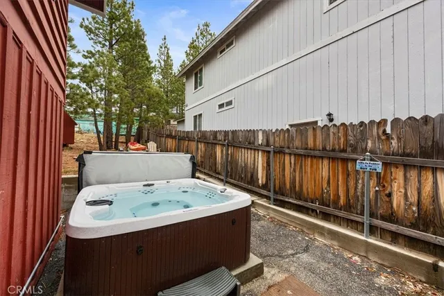 a view of a backyard with a tub and wooden fence
