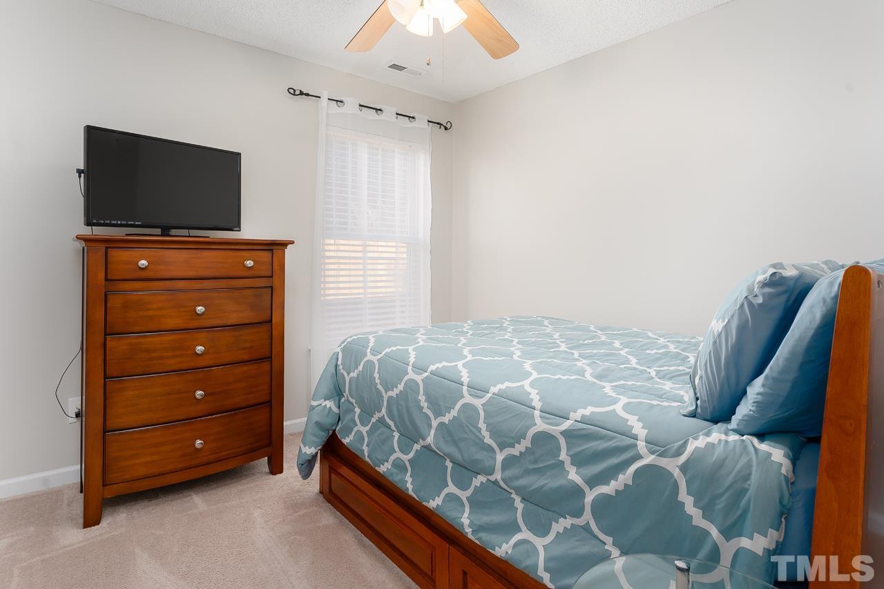 3815 Hopper Street Raleigh, NC 27616 - Photo 14 of 18 a bedroom with a bed and a flat tv screen on a dresser