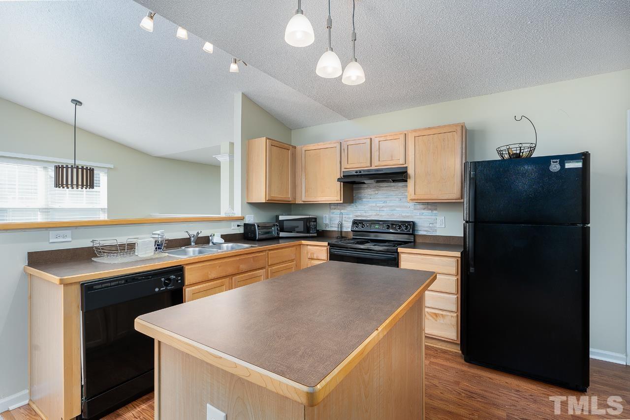 3815 Hopper Street Raleigh, NC 27616 - Photo 8 of 18 a kitchen with a refrigerator a sink dishwasher and a stove with wooden floor