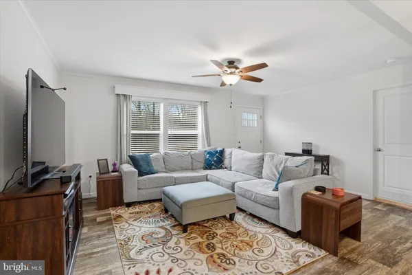 a living room with furniture a flat screen tv and a window